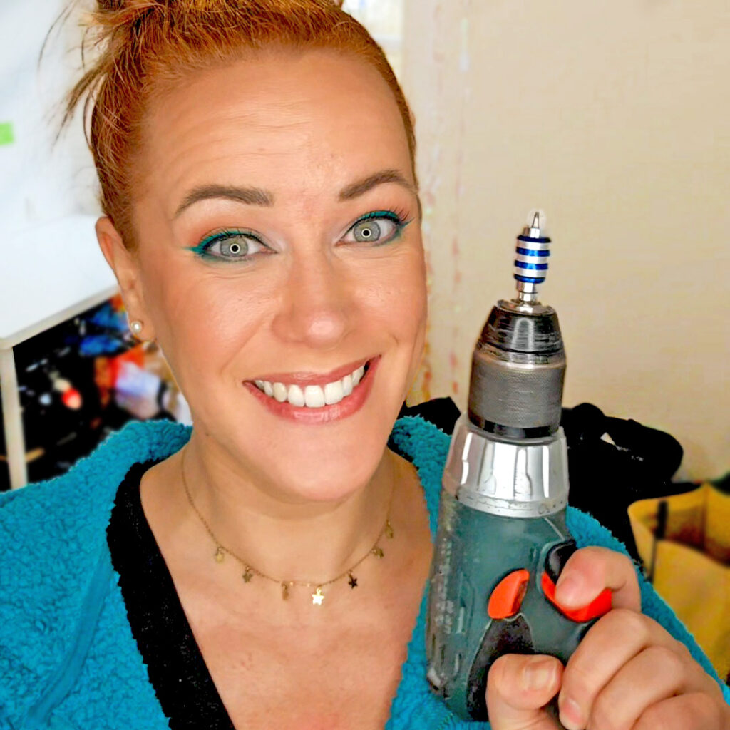 Léa Lafarge, maquilleuse et coach beauté holistique, souriante avec une perceuse à la main en clin d'œil à ses outils atypiques de transformation intérieure