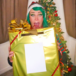 Léa Wake Up déguisée en lutin tenant un gros paquet cadeau, une maquilleuse fun et créative à Roanne proposant des bons cadeaux beauté et bien-être.