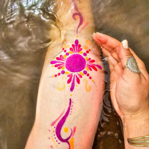 Body art waterproof rose et doré sur la jambe, immergé dans l’eau – maquillage résistant à l’eau.