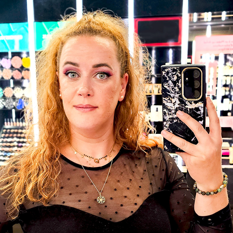 Léa Wake Up dans une boutique de maquillage, regard franc et bienveillant, pour illustrer le service d’accompagnement express SOS Good Vibes