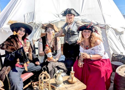 animation-maquillage-deguisement-fete-costumee-pirates-leawakeup Groupe de femmes déguisées en pirates, réunies devant une tente lors d’une fête costumée avec accessoires et maquillage artistique.